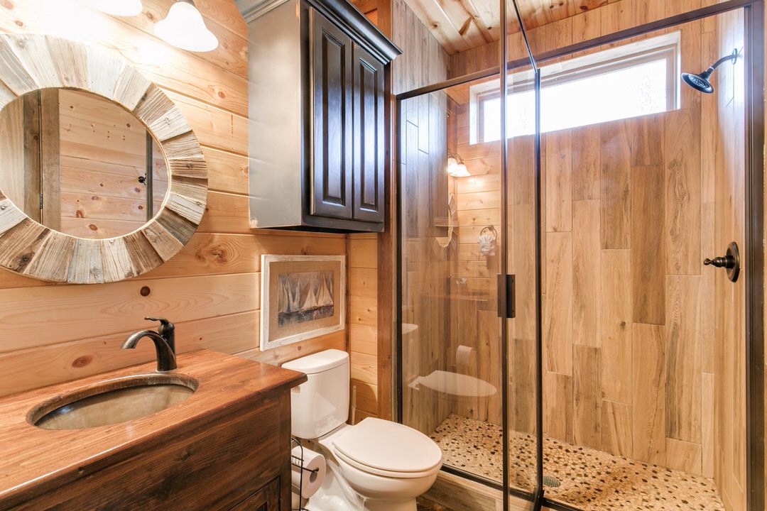 A well-appointed bathroom in a Broken Bow cabin, showcasing a shower, toilet, and sink for guest convenience.