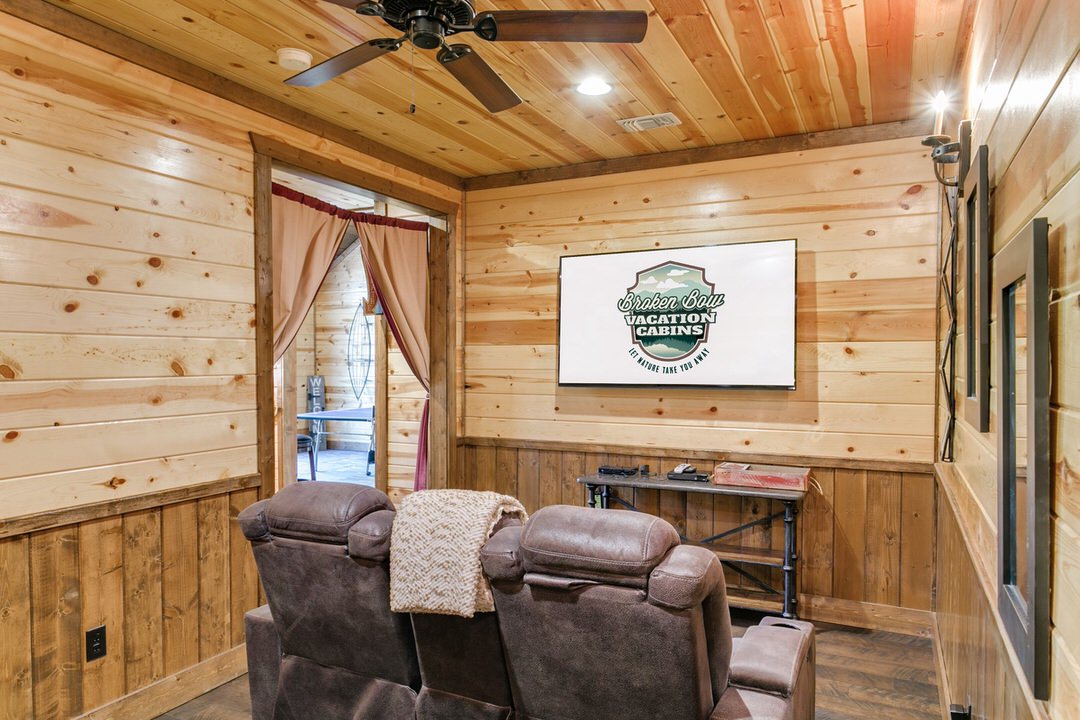Interior of a Broken Bow cabin living room showcasing a television and a plush couch for relaxation.