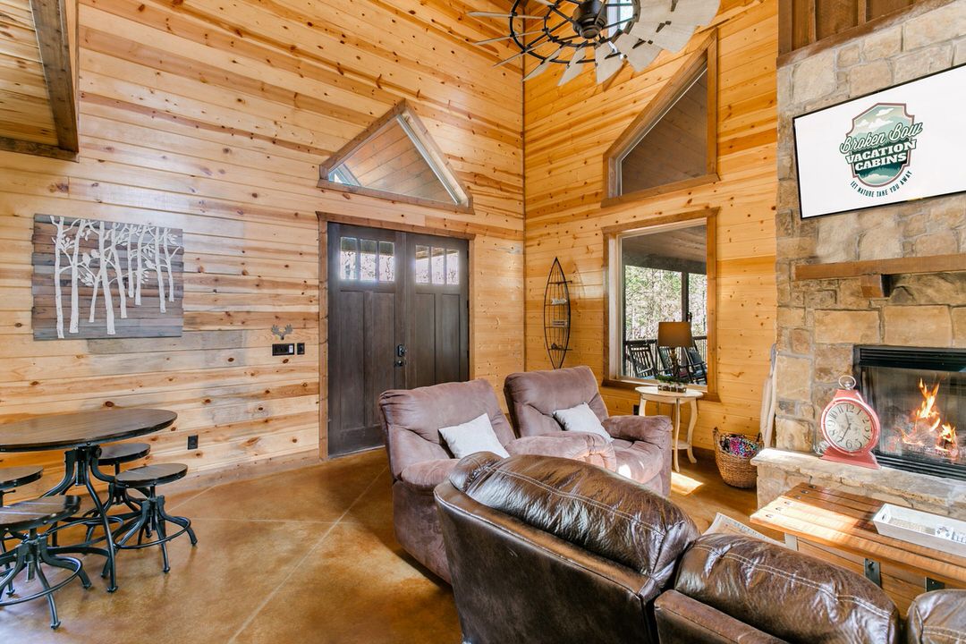 Charming cabin living room in Broken Bow, showcasing a fireplace and plush couches for a warm atmosphere.