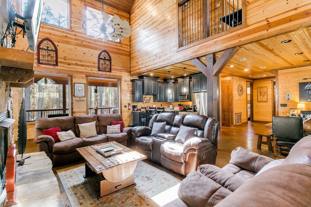 Warm living room setting in a Broken Bow cabin, complete with stylish couches and a welcoming fireplace for comfort.