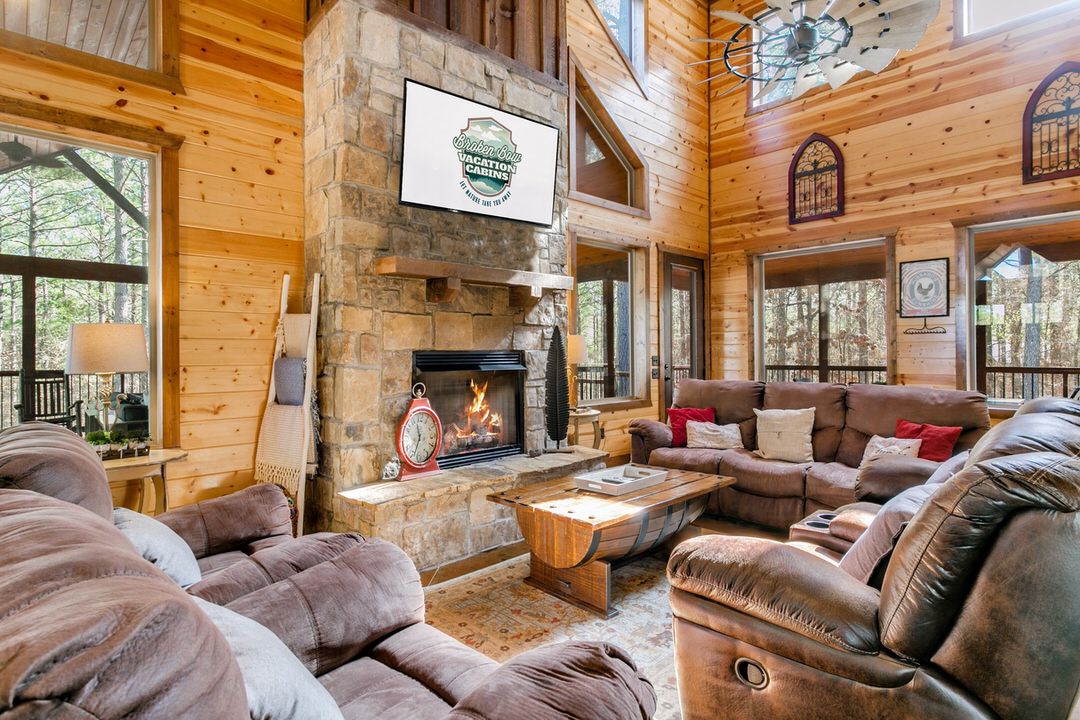 Cozy living room in a Broken Bow cabin, featuring a fireplace and comfortable couches for relaxation.