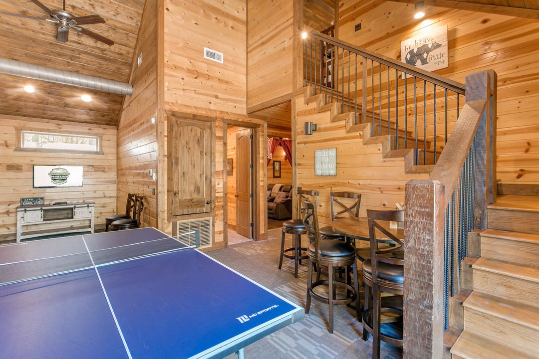 A ping pong table set up in a cozy log cabin in Broken Bow, Oklahoma, inviting guests for a fun game.